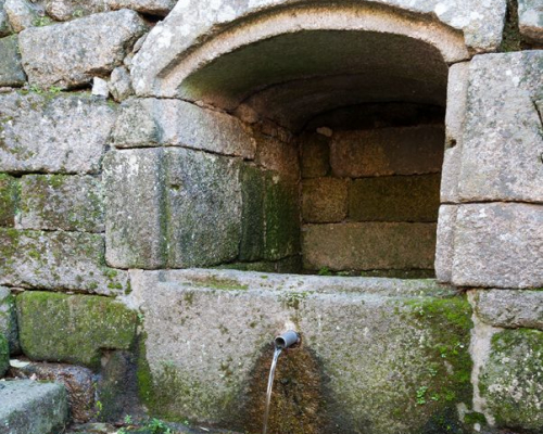 Fuente baja protegida con vano con dintel ligeramente arqueado con la inscripción «1722».